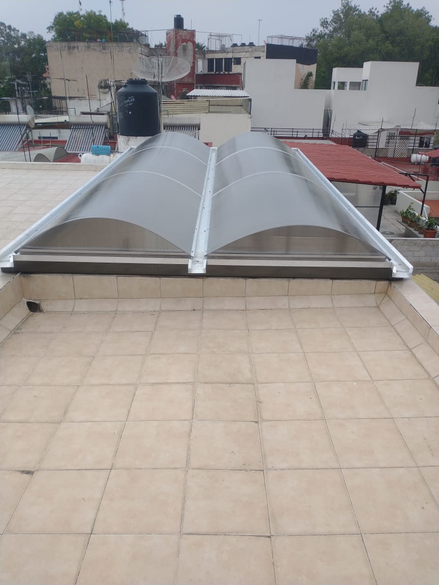 domo de policarbonato con escotilla para evita la humedad y permite mejorar la ventilación, sostenido por aluminio | Acrilfrasa.mx